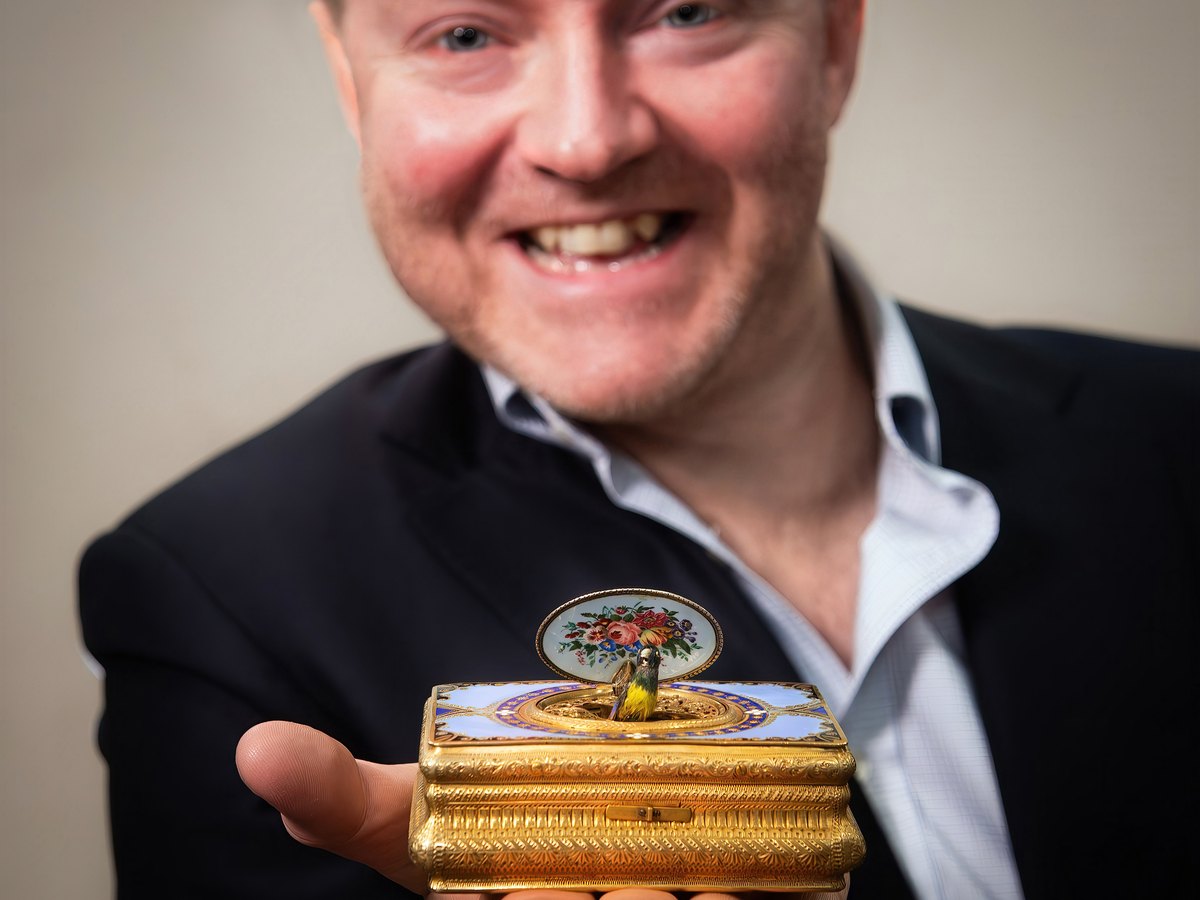 A specialist at Elstob Auctioneers with a singing bird box